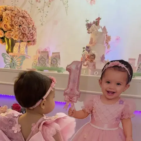 Bebês de vestido rosa na festa de primeiro aninho