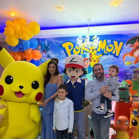 Família com personagens fantasiados de Pikachu e Ash na festa Pokémon