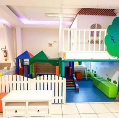 Área baby cercada, com casinha de brinquedo e escorregador para os pequenos
